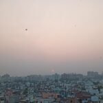 Kites flying over a city at sunset, illustrating the Faisalabad kite flying crackdown