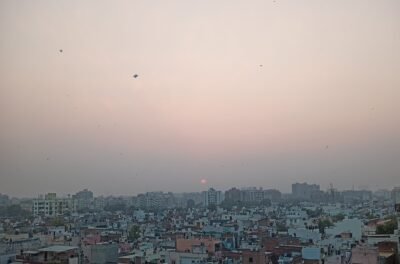 Kites flying over a city at sunset, illustrating the Faisalabad kite flying crackdown
