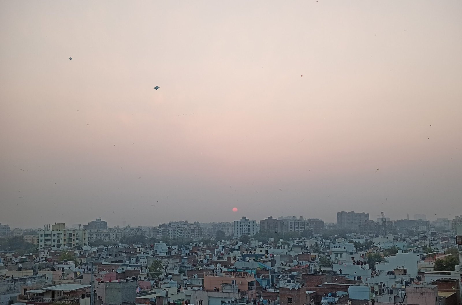 Kites flying over a city at sunset, illustrating the Faisalabad kite flying crackdown